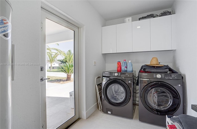 washroom featuring cabinets, separate washer and dryer, and light tile patterned floors