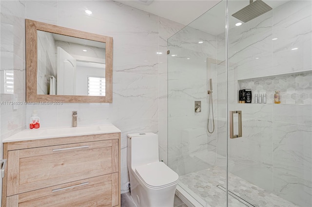 bathroom with a shower with door, tile walls, backsplash, vanity, and toilet