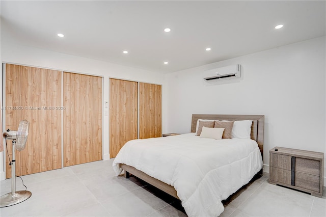 bedroom featuring an AC wall unit and multiple closets