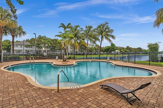 view of pool featuring a water view and a patio area