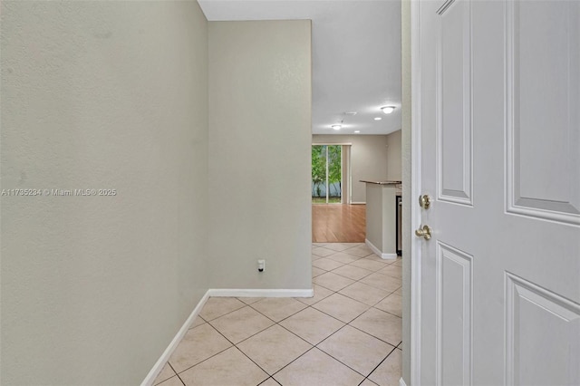 hall with light tile patterned floors