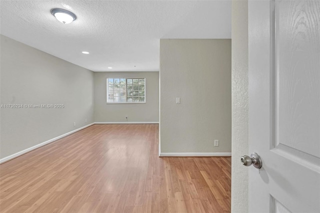 empty room featuring a textured ceiling and light wood-type flooring