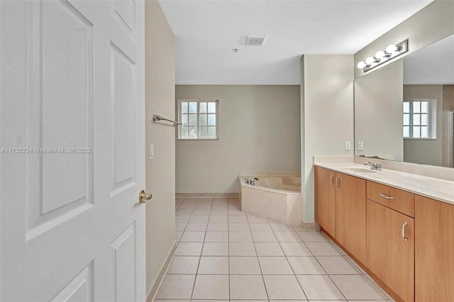 bathroom with vanity, plenty of natural light, tile patterned floors, and a tub to relax in