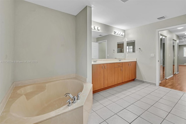 bathroom with a washtub, vanity, and tile patterned floors