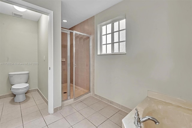 bathroom featuring walk in shower, tile patterned floors, and toilet