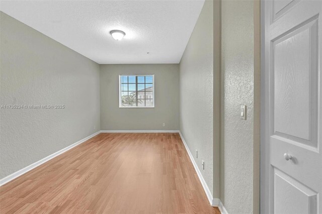 unfurnished room featuring hardwood / wood-style floors and a textured ceiling