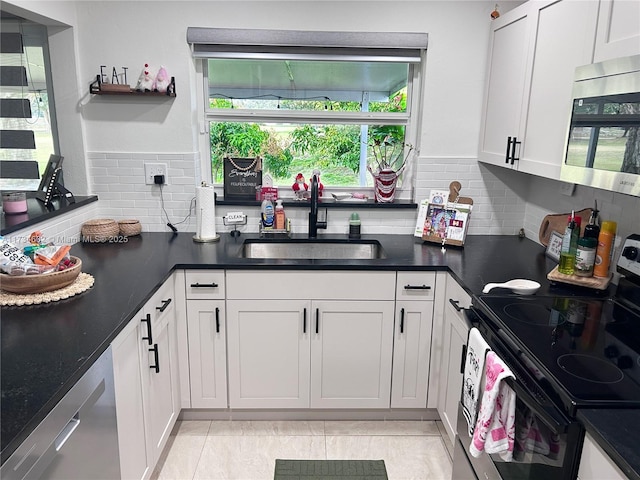 kitchen with stainless steel appliances, tasteful backsplash, sink, and white cabinets