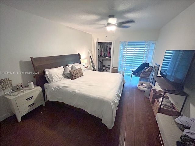 bedroom with dark hardwood / wood-style floors, a textured ceiling, and ceiling fan