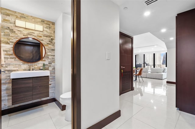 hall featuring sink and light tile patterned floors