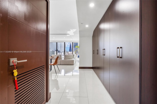 corridor featuring expansive windows and light tile patterned flooring