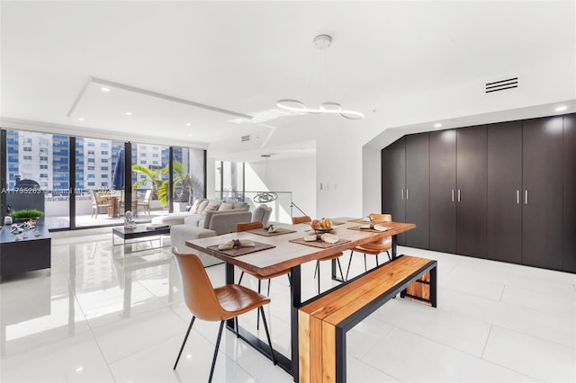 tiled dining room featuring a wall of windows