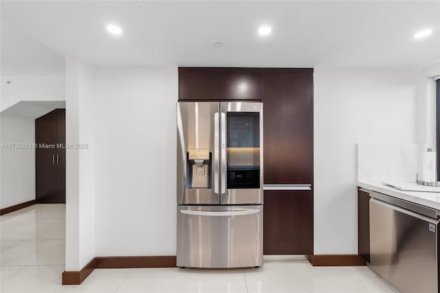 kitchen featuring light tile patterned flooring, appliances with stainless steel finishes, and dark brown cabinets