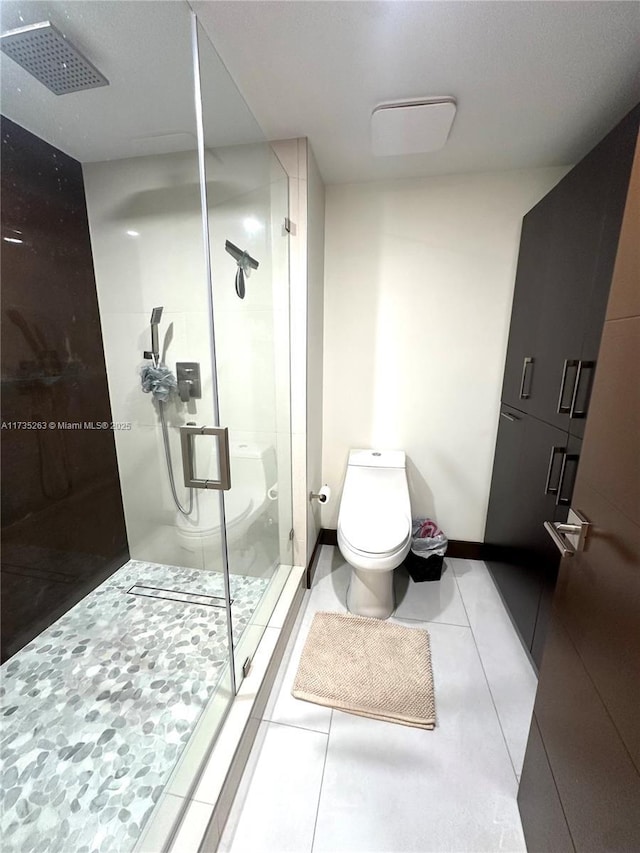 bathroom featuring tile patterned flooring, toilet, and walk in shower