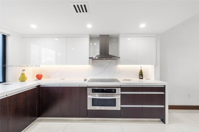 kitchen with dark brown cabinetry, white cabinets, black electric cooktop, oven, and wall chimney exhaust hood