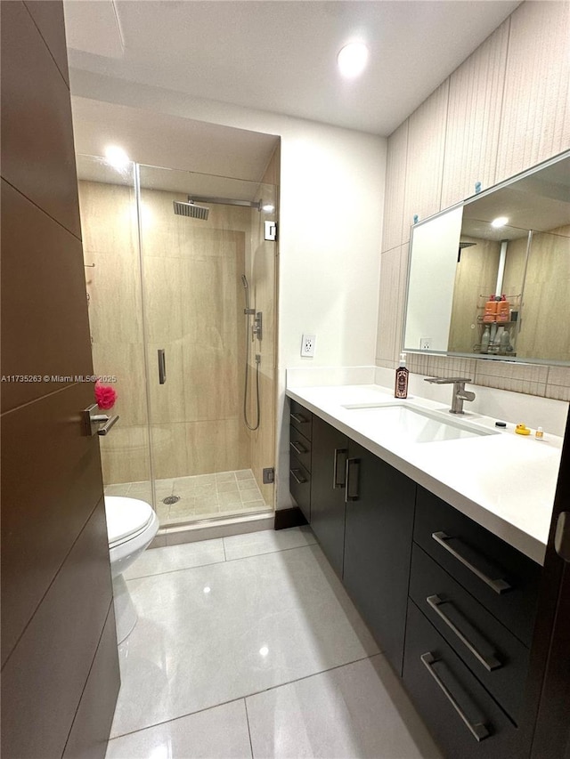 bathroom featuring vanity, tile patterned flooring, a shower with door, and toilet