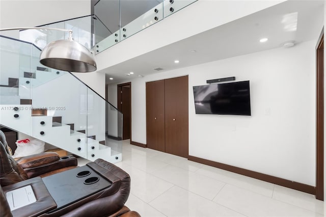 living room featuring light tile patterned flooring and a towering ceiling