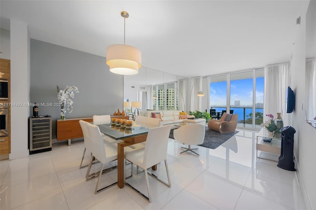 tiled dining area with floor to ceiling windows, a water view, and beverage cooler