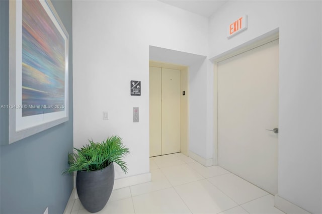 hallway with light tile patterned flooring and elevator