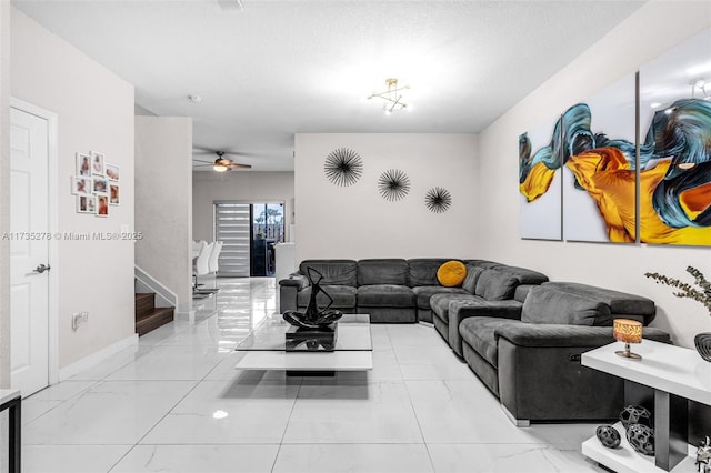 living room featuring ceiling fan and a textured ceiling