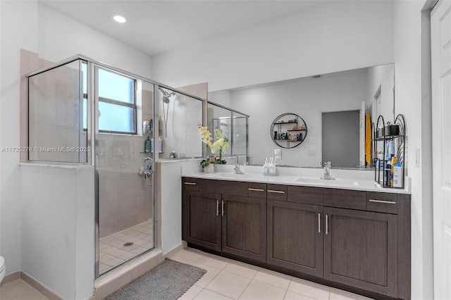 bathroom featuring a shower with door, vanity, and tile patterned floors