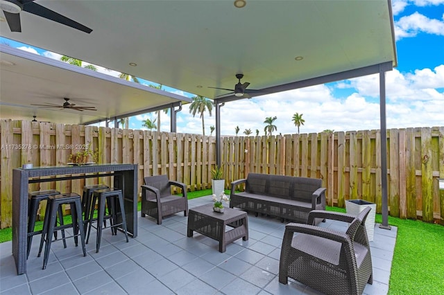 view of patio / terrace with an outdoor living space, exterior bar, and ceiling fan