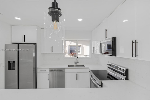 kitchen with appliances with stainless steel finishes, sink, and white cabinets