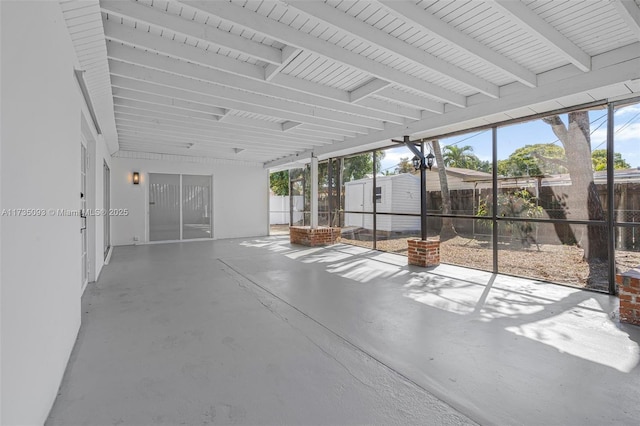 unfurnished sunroom with plenty of natural light and beam ceiling