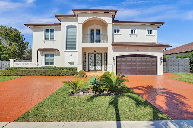 mediterranean / spanish home with a garage, french doors, and a balcony