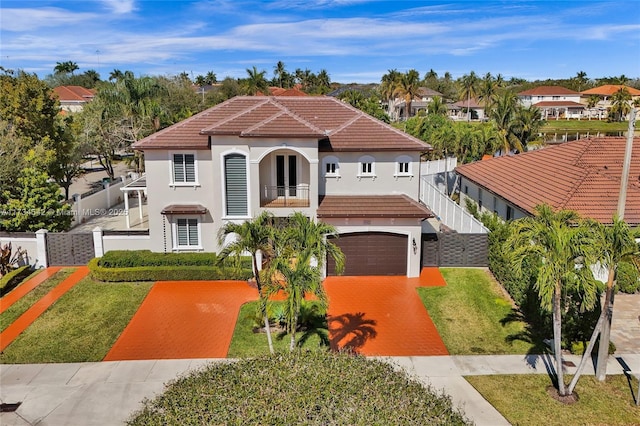 mediterranean / spanish home featuring a balcony, a garage, and a front yard