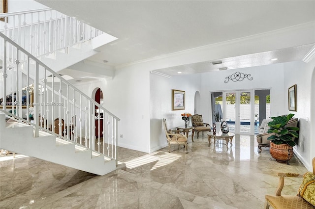 stairs featuring crown molding and french doors