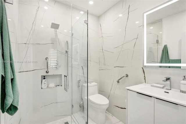 bathroom featuring a shower with door, vanity, tile walls, and toilet