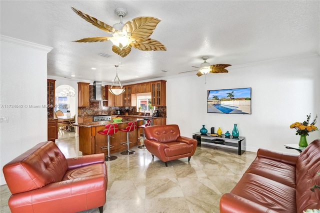 living room with crown molding, ceiling fan, and a textured ceiling