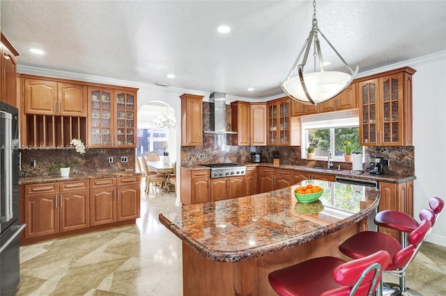 kitchen featuring sink, stainless steel appliances, a center island, and wall chimney exhaust hood