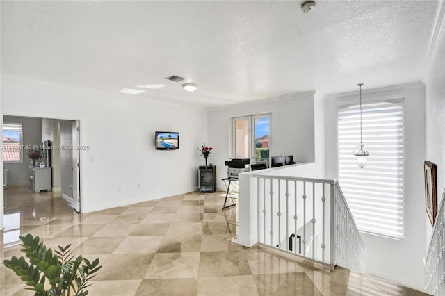 hallway featuring ornamental molding and a textured ceiling