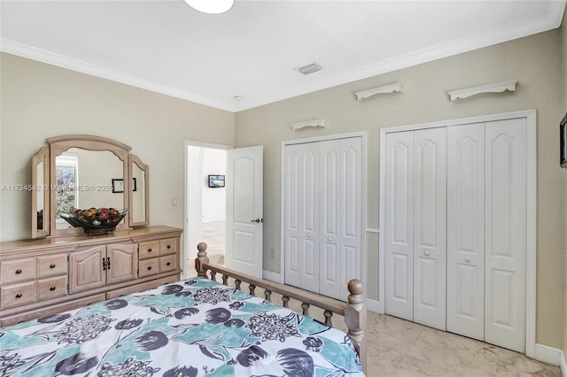 bedroom featuring crown molding and two closets