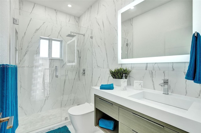 bathroom with toilet, tile walls, vanity, a shower with door, and backsplash