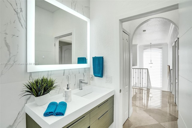 bathroom featuring vanity, decorative backsplash, and a textured ceiling