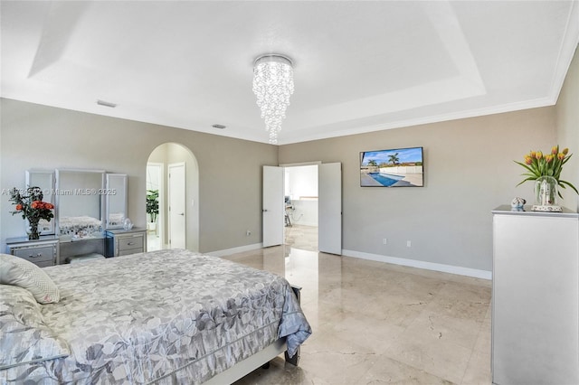 bedroom featuring a tray ceiling and a chandelier