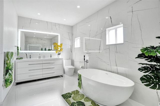 full bathroom with vanity, tile walls, toilet, and separate shower and tub