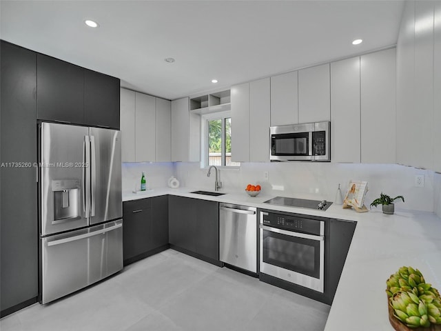 kitchen with white cabinetry, sink, backsplash, and appliances with stainless steel finishes