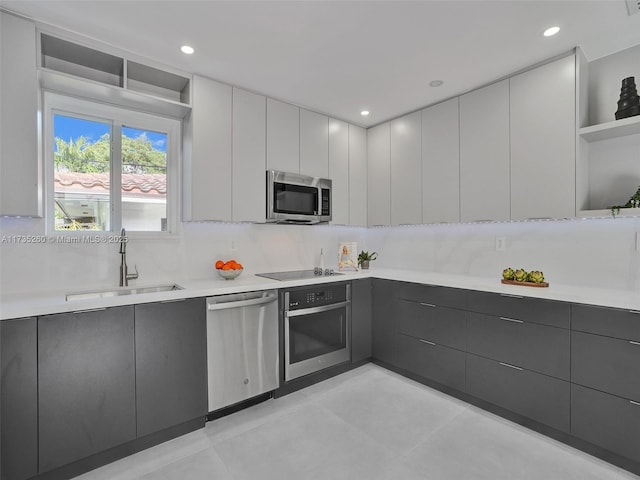 kitchen featuring tasteful backsplash, appliances with stainless steel finishes, sink, and white cabinets