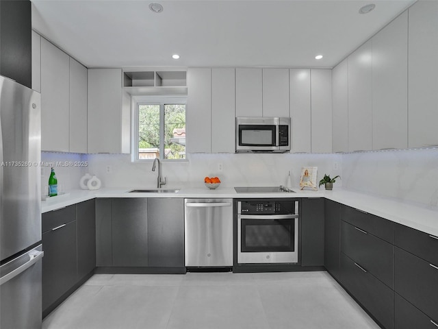 kitchen featuring light tile patterned flooring, sink, tasteful backsplash, appliances with stainless steel finishes, and white cabinets