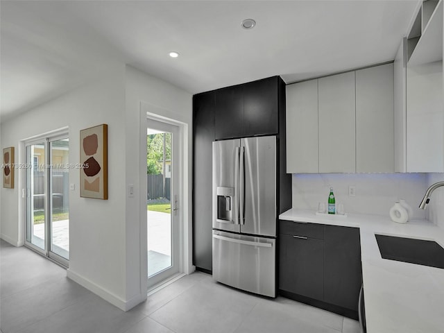 kitchen featuring stainless steel fridge with ice dispenser, sink, and white cabinets