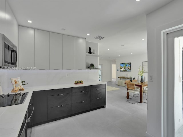 kitchen with black electric stovetop and white cabinets