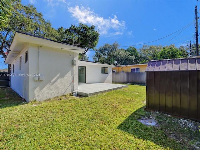 back of property with a patio area, a shed, and a lawn