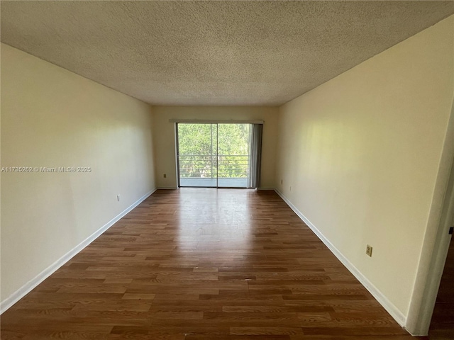 unfurnished room with a textured ceiling and dark hardwood / wood-style flooring