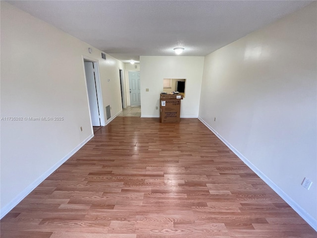 unfurnished room featuring hardwood / wood-style floors and a textured ceiling