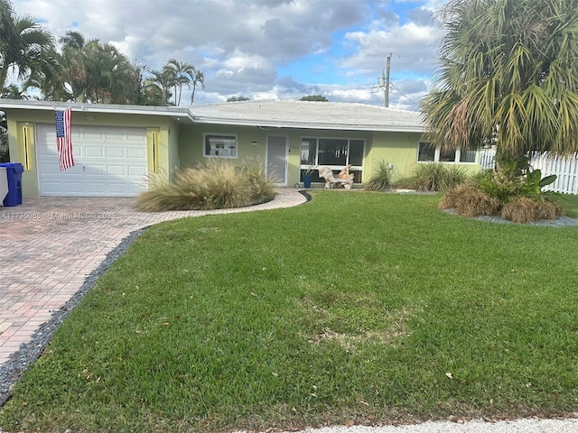 ranch-style house featuring a garage and a front lawn