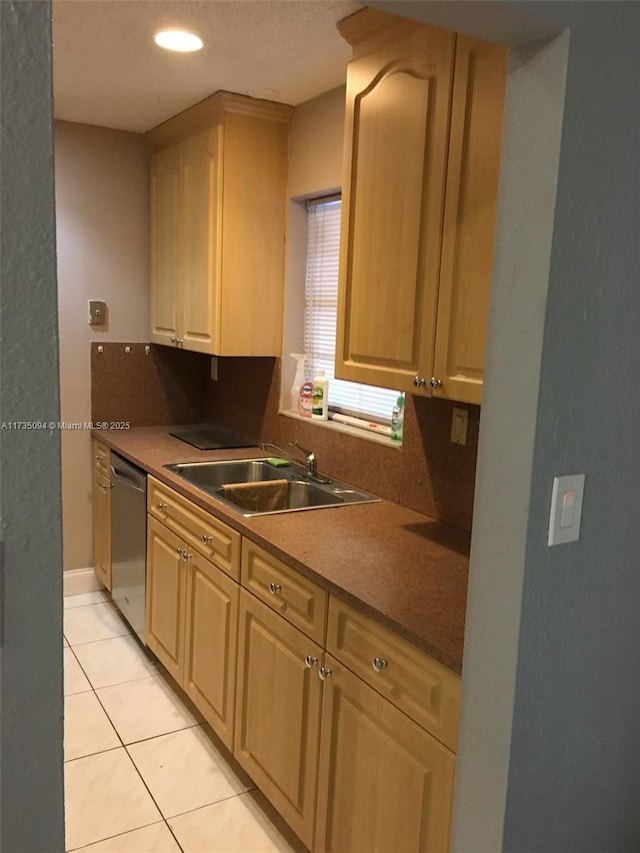 kitchen with light brown cabinetry, sink, a textured ceiling, light tile patterned floors, and stainless steel dishwasher