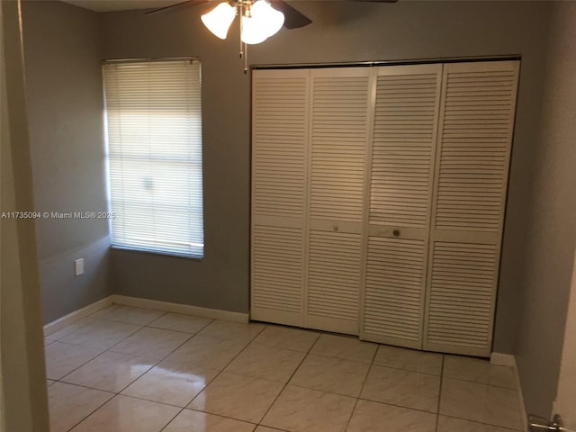 unfurnished bedroom featuring light tile patterned floors, a closet, and ceiling fan